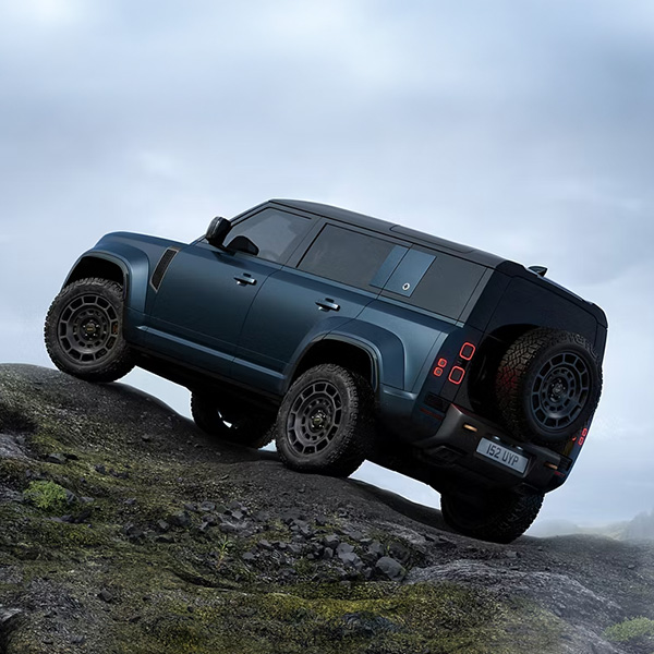 Back view of the 2026 Defender 110 parked on a rocky cliff.