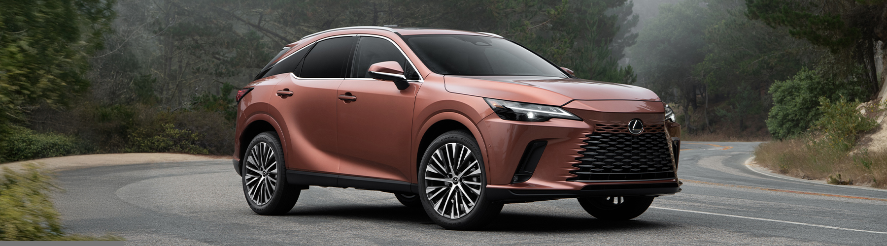2026 Lexus RX luxury SUV shown from front three-quarter view on a winding road