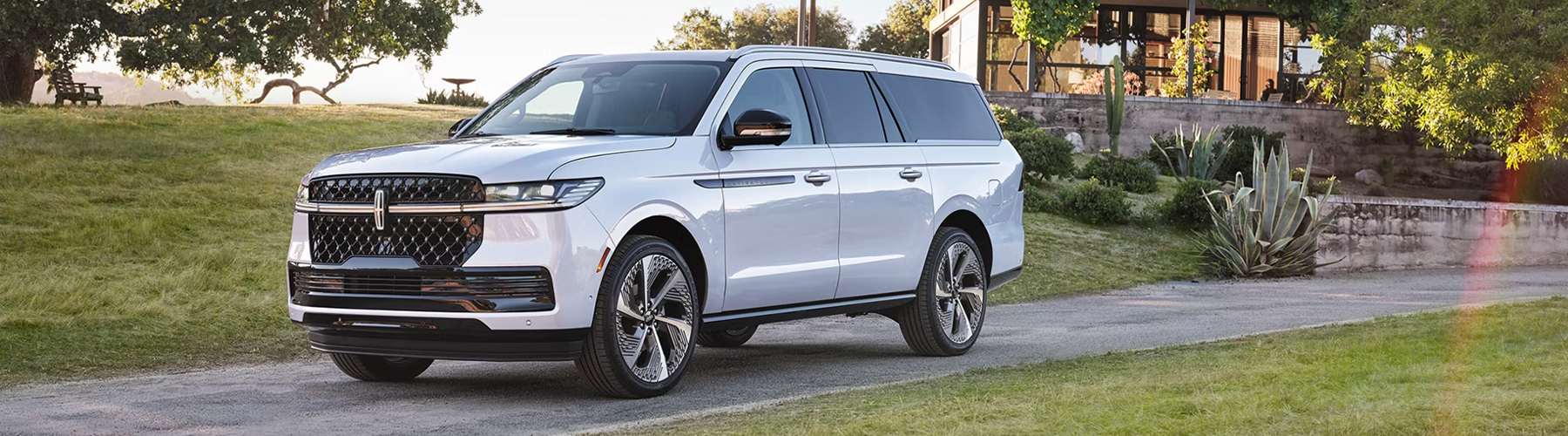 A 2026 Lincoln Navigator® with the available Atmospheric Black Label theme is parked in front of a modern home