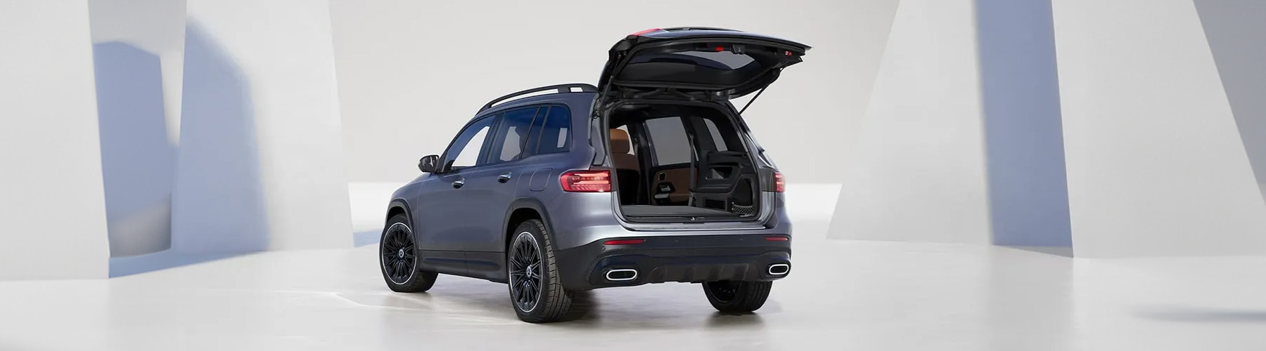 3/4 Rear view of the 2026 Mercedes-Benz GLB parked in a modern studio setting with the trunk open