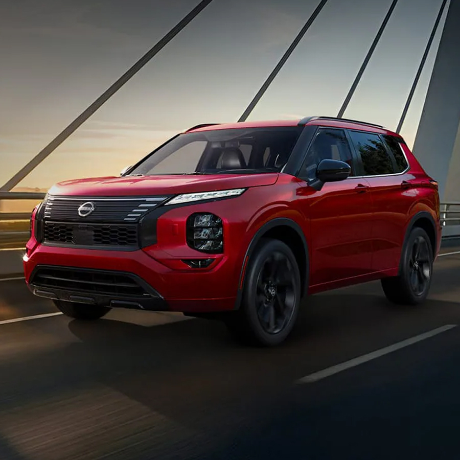 2026 Nissan Rogue Plug-in Hybrid 3/4 front view driving with cityscape and bridge in the background.