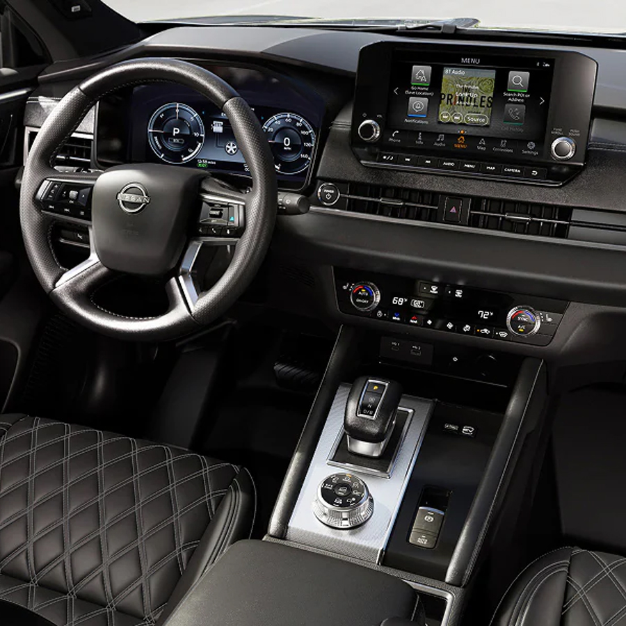 2026 Nissan Rogue Plug-in Hybrid interior view from front passenger seat showing steering wheel, dashboard and console. (screen showing menu)