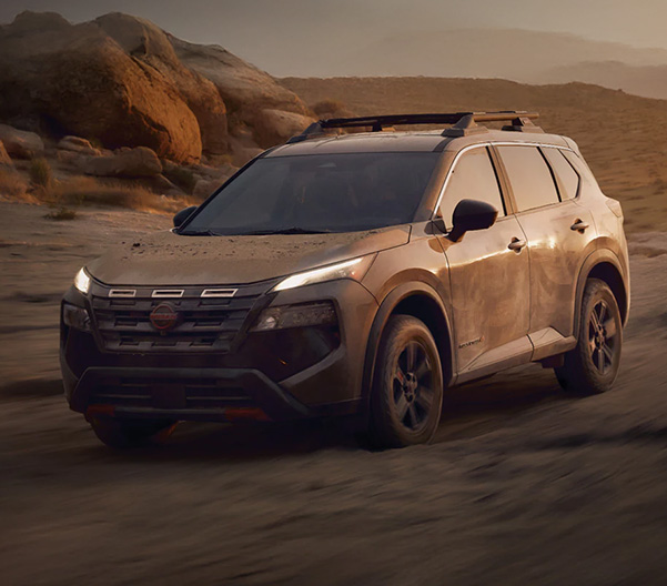 A Nissan Rogue Rock Creek compact SUV driving through the desert, showcasing its rugged capabilities
