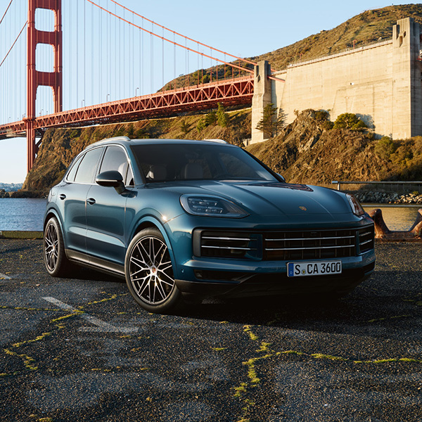 Front 3/4 shot of the Porsche Cayenne parked in front of bridge
