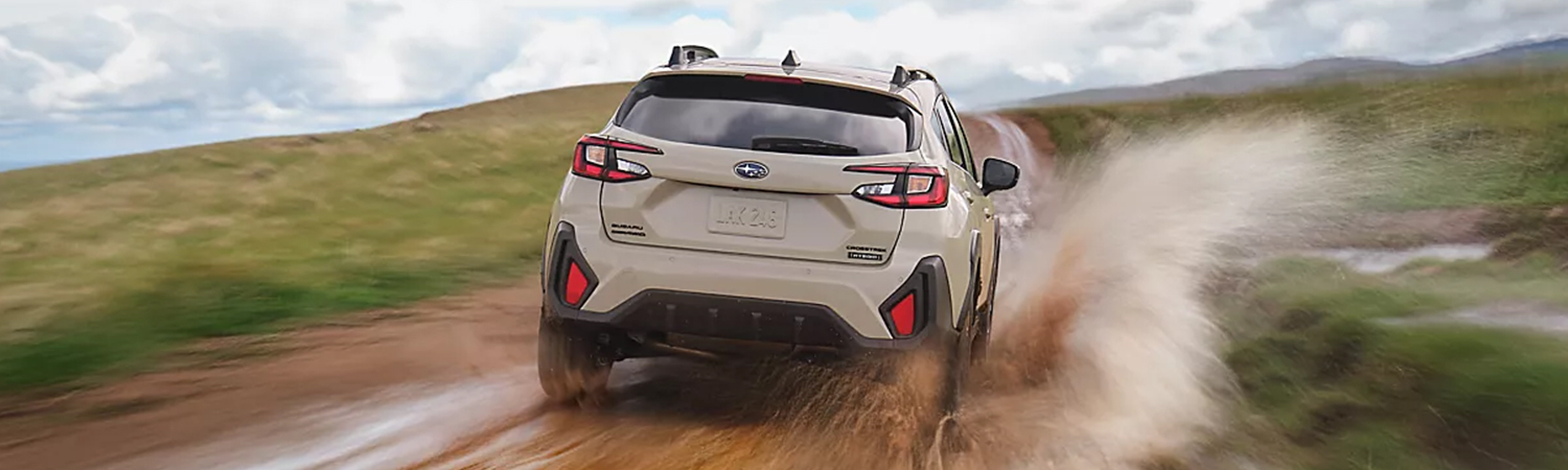 Rear 3/4 shot of the 2026 Subaru Crosstrek Hybrid driving off road