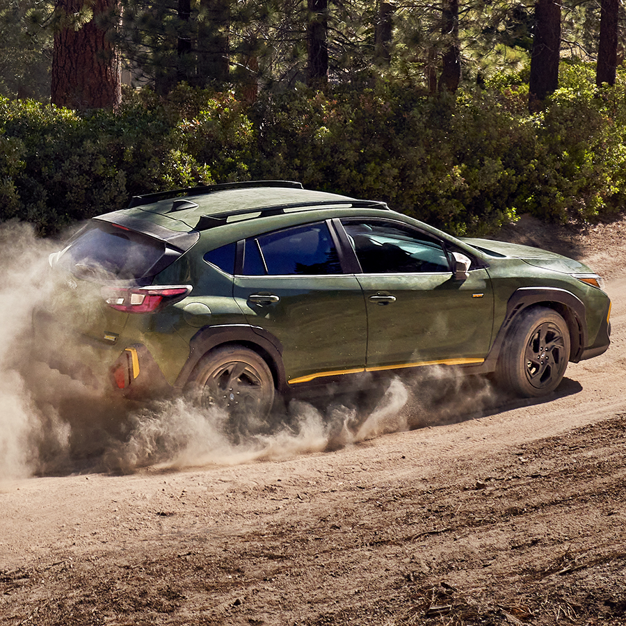 2026 Subaru Crosstrek Sport driving through woods.