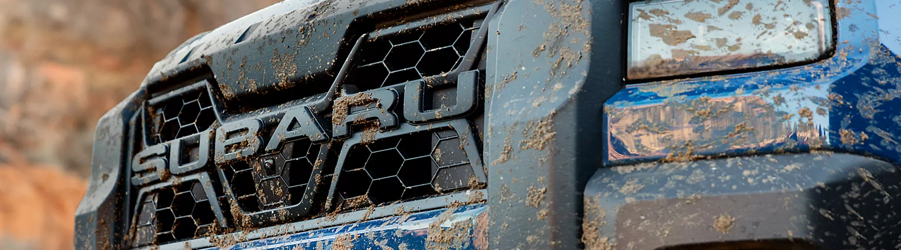 A close-up of the grill on a blue 2026 Subaru Outback Wilderness.