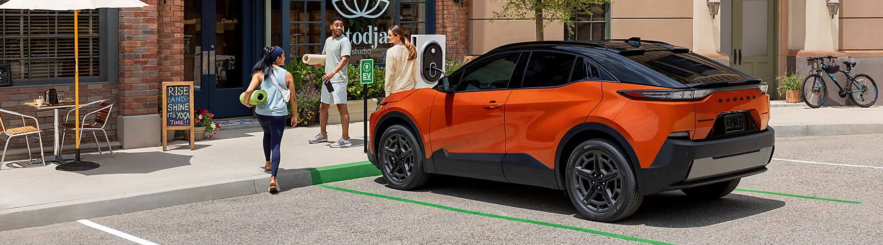 Subaru electric vehicle SUV parked outside retail storefront