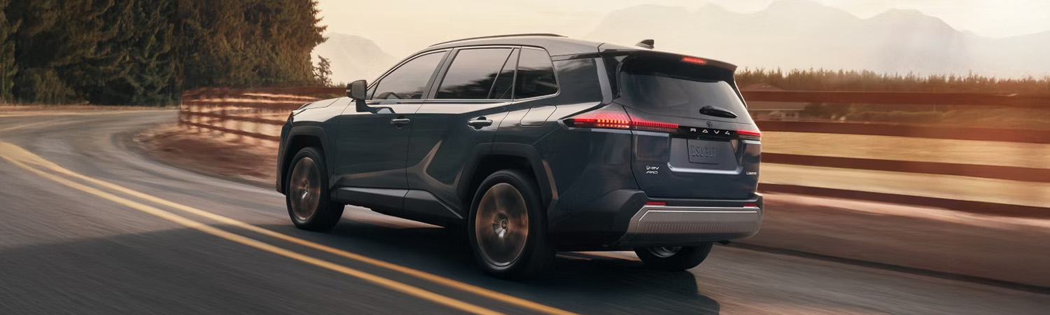 Rear 3/4 shot of the 2026 Toyota RAV4 turning onto road