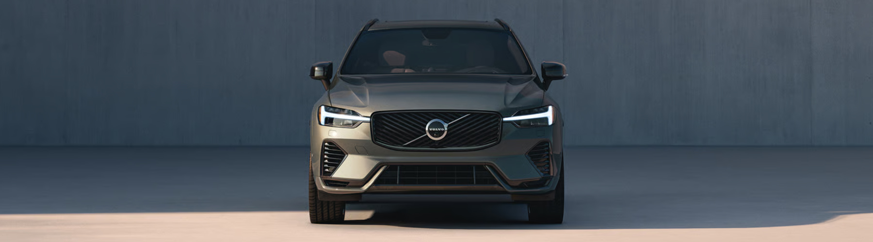Front view of the Volvo XC60 midsize plug-in hybrid SUV, emphasizing its front grille and LED headlights.