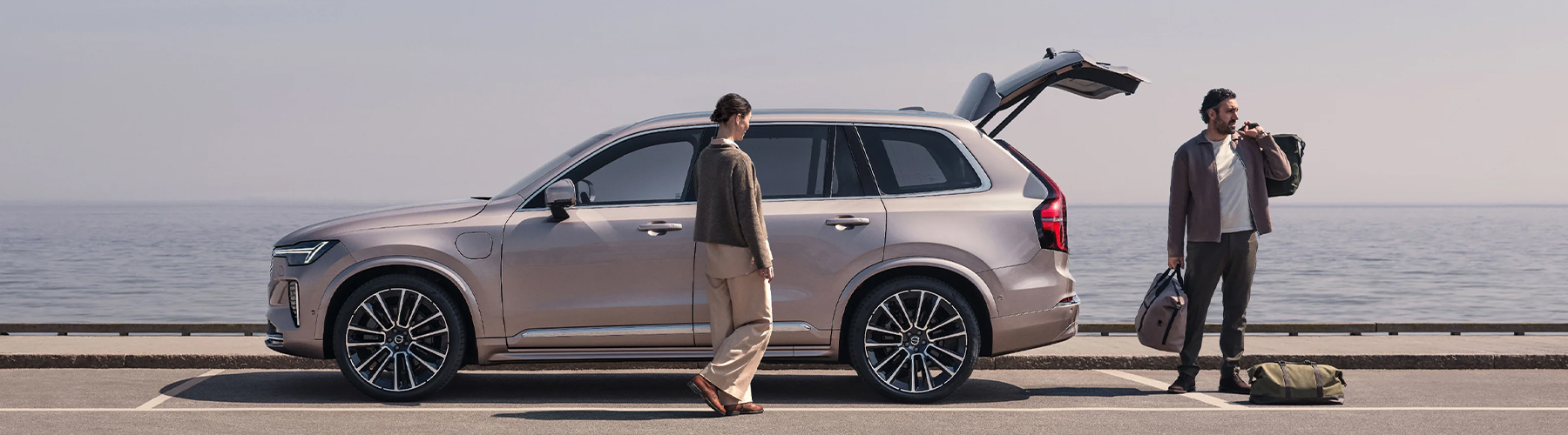 A woman and a man packing their Volvo XC90 next to the water