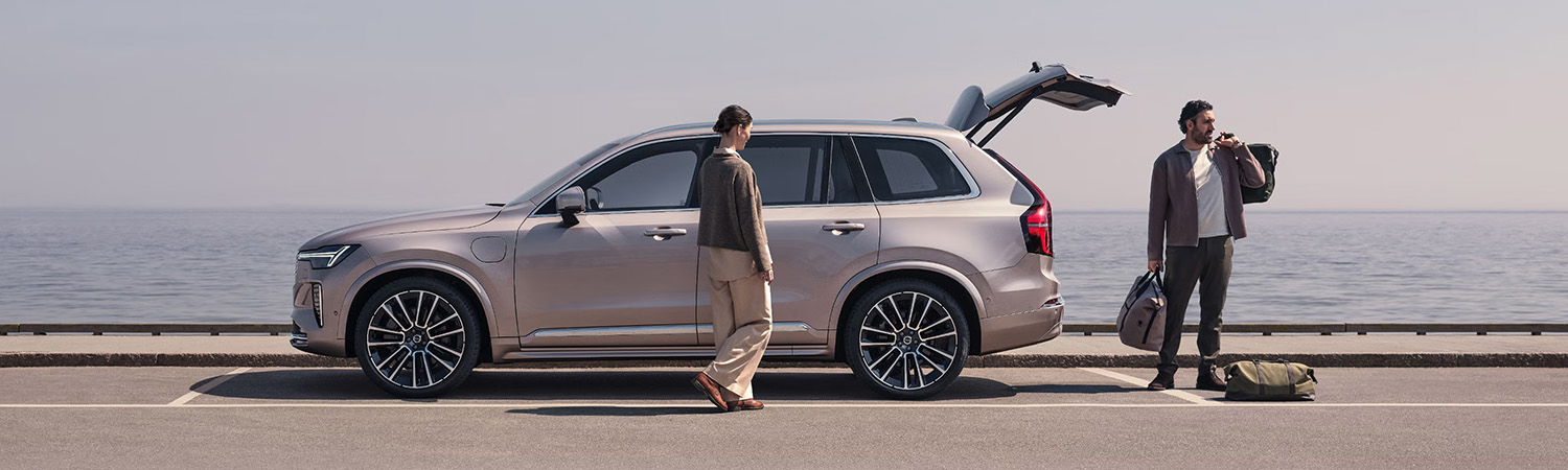 A woman and a man packing their Volvo XC90 next to the water