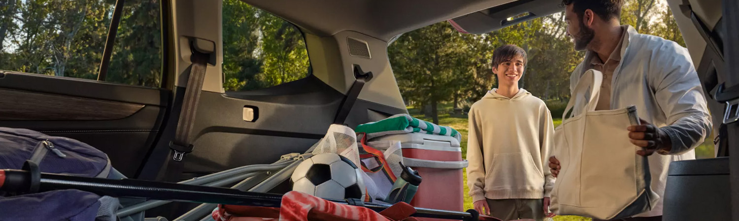Interior shot of a 2026 VW Atlas with a family loading up camping gear