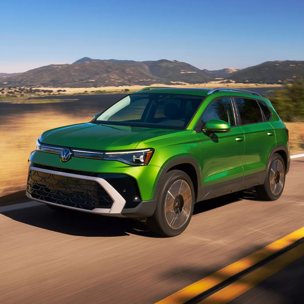 Green VW 2026 Taos driving on a road