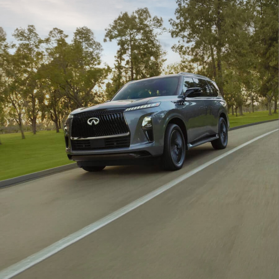 Exterior front profile of 2027 INFINITI QX80 Luxury SUV driving down the road