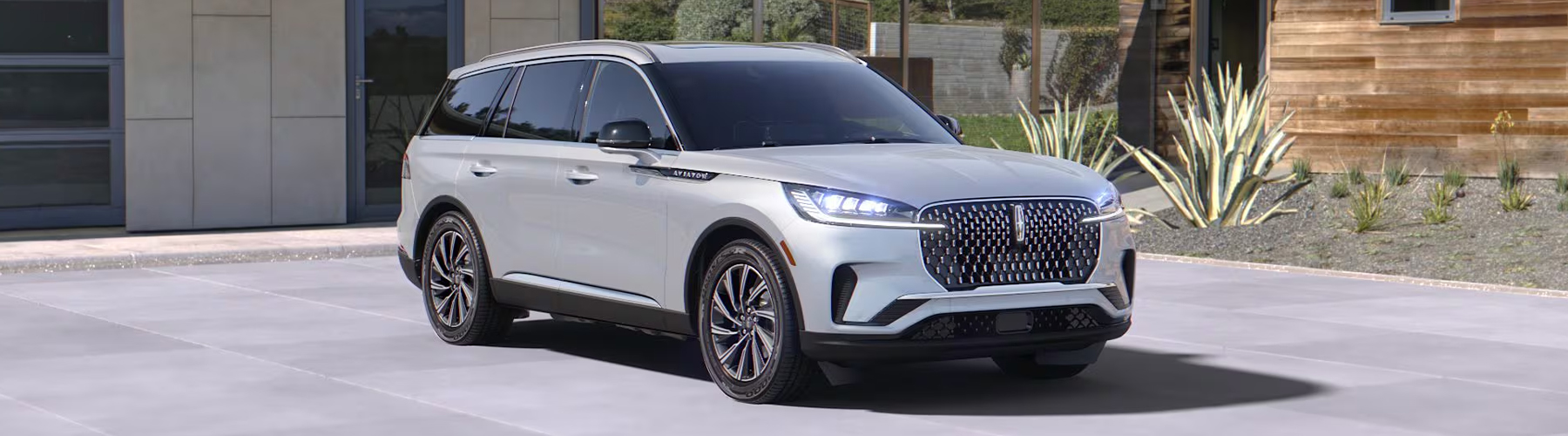 A 2027 Lincoln Aviator® SUV is parked outside a home