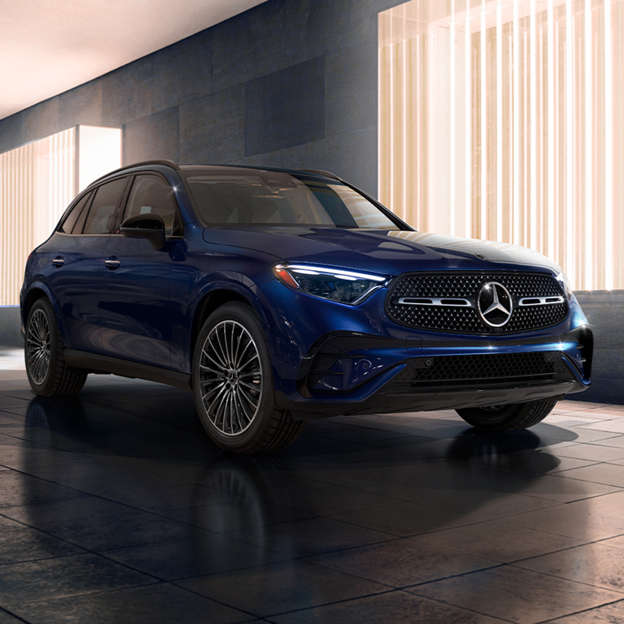 2027 Mercedes-Benz GLC blue luxury SUV parked outside a modern building, highlighting its sporty exterior styling