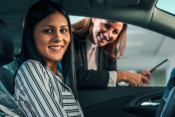 Young woman sitting in brand new car.