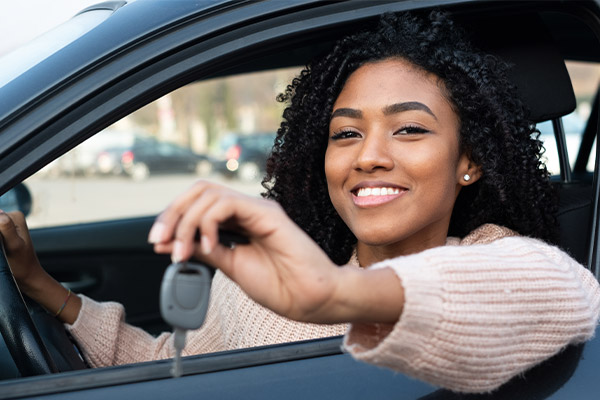 Young woman sitting in brand new car.