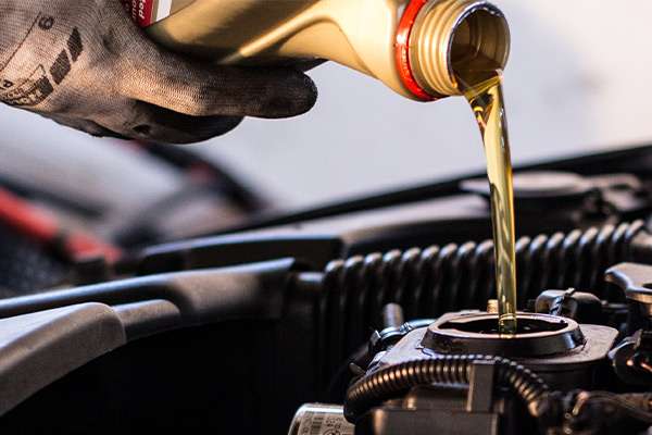 Mechanic fills the engine with engine oil