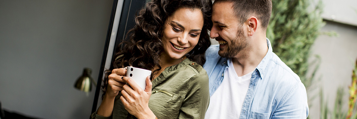 Happy couple in love embracing each other and drinking coffee