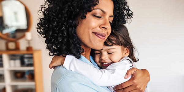 Mom and her cute little daughter hugging at home