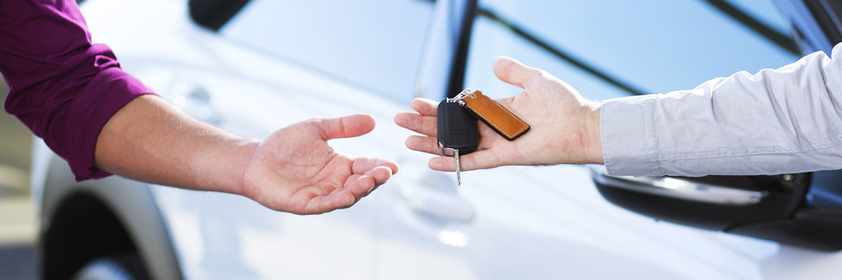 close-up of car seller's hand with keys and buyer's hand after transaction