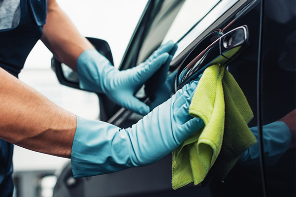 Car cleaner wiping car door with rag