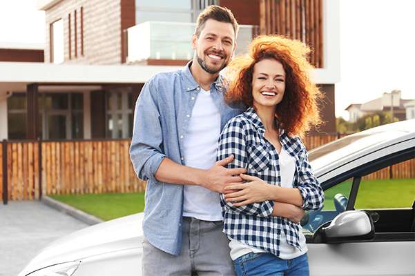 Happy young couple near car