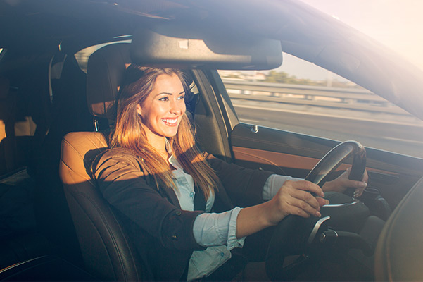 Woman driving car at sunset