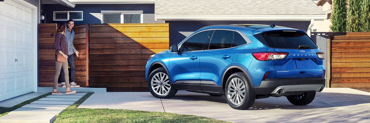 Family looking at Ford Escape parked in front of house