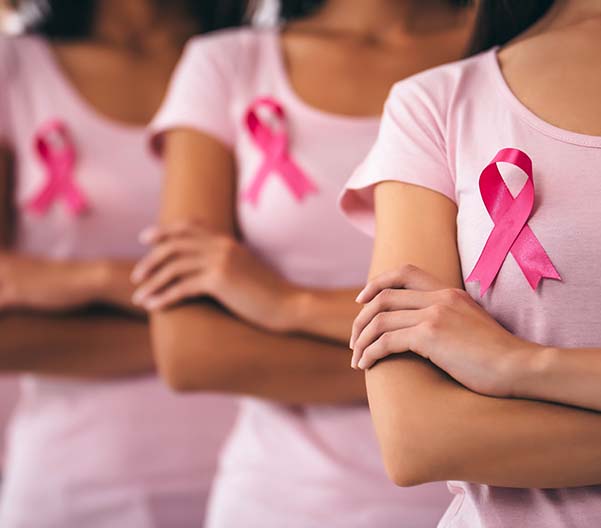 Woman standing side-by-side with Breast Cancer Awareness ribbon