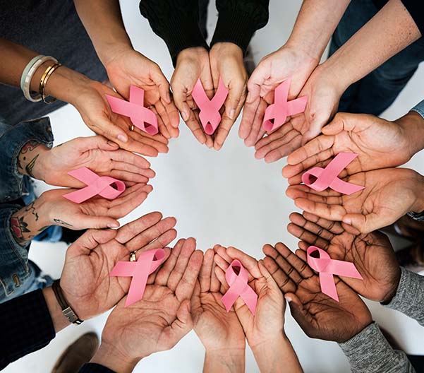 Hands in a circle holding Breast Cancer Awareness ribbons