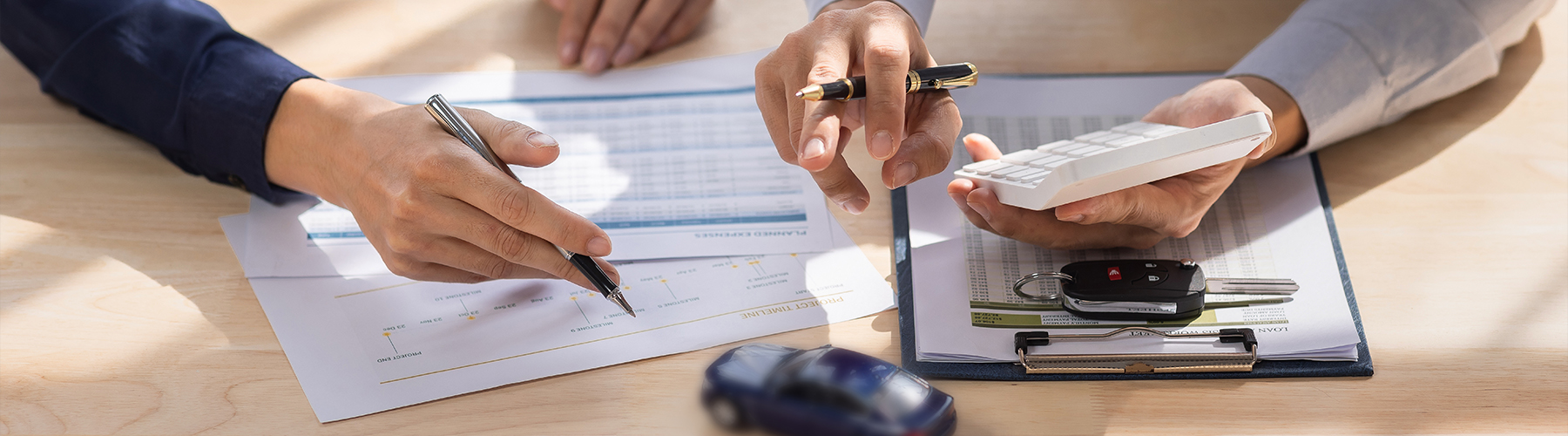 Car Insurance document or lease concept the car broker assisting his customer and explaining the detail of the car contact. Car key Buying or selling
