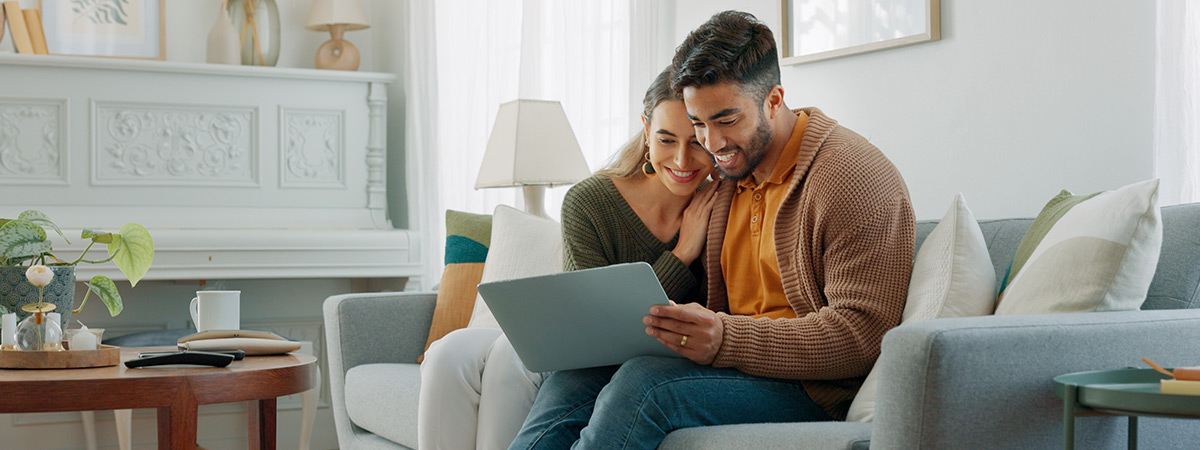 Laptop, living room and couple search website information for home investment, loan or real estate property discussion on sofa.