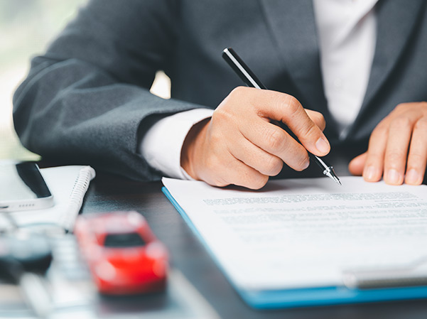 Car dealer business woman signing car insurance document or lease paper.