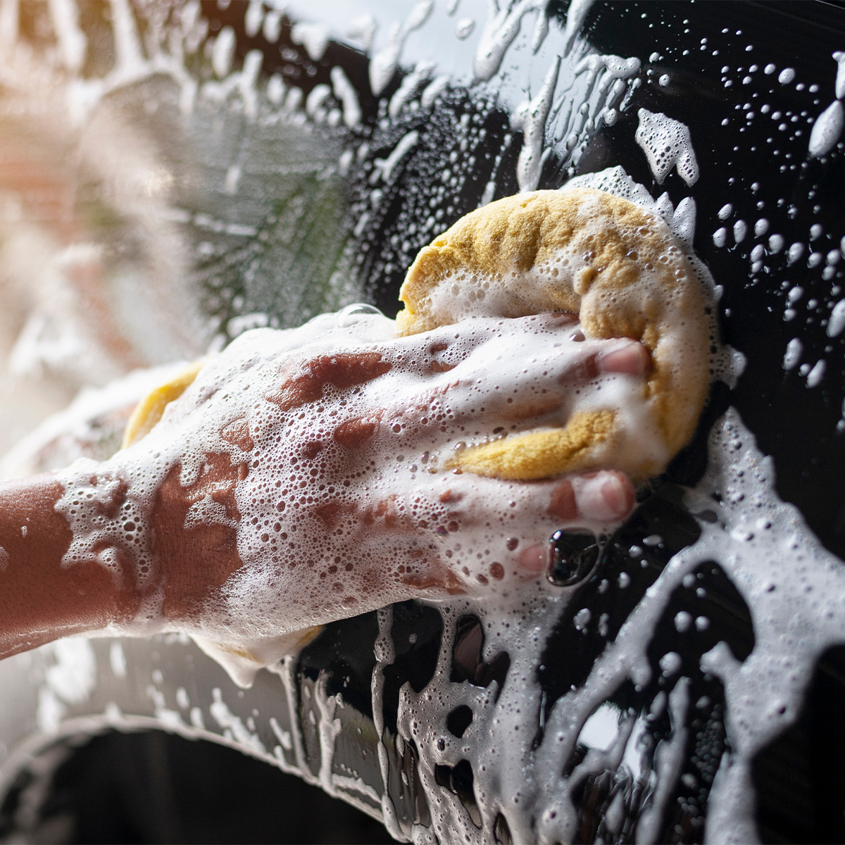 Hand washing car with sponge.