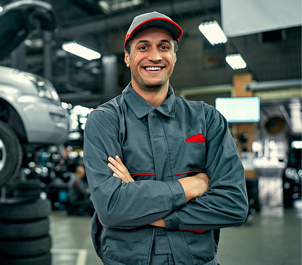 Auto technician standing and smiling in service center