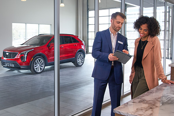Employee talking with customer with Cadillac XT4 in the background