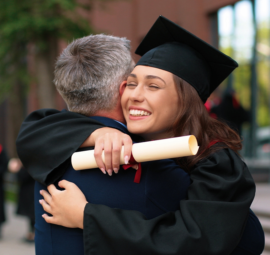 College graduate smiling hugging family member