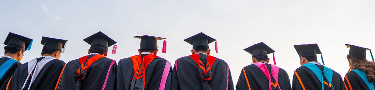 College grads lineup up in caps and gowns