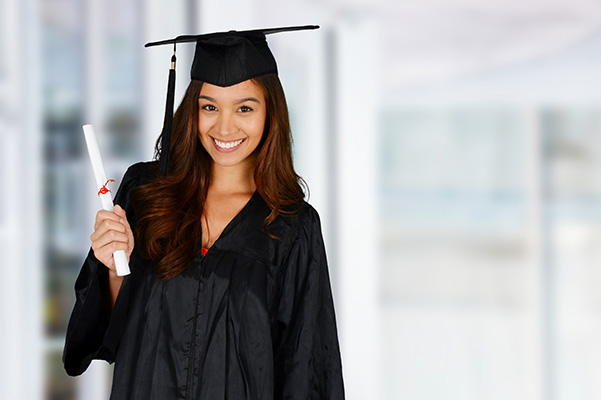 Female college graduate posing with her diploma in her cap and gown