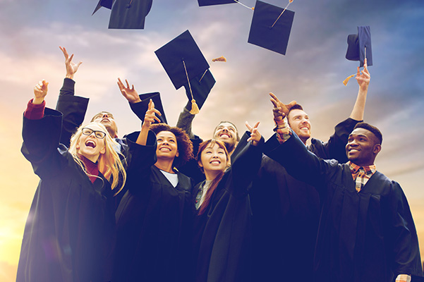 Group of college graduates throwing their caps in the air