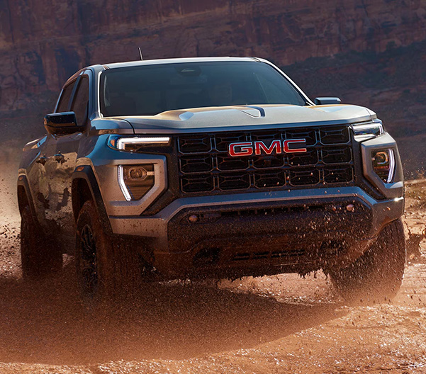 Three-quarters View of the 2025 GMC Canyon Truck Driving Through the Desert