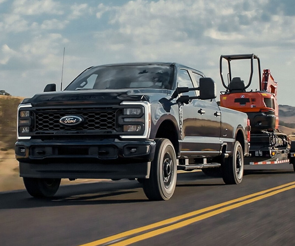 2025 Ford Super Duty® F-250® STX® pulling a tractor on a trailer
