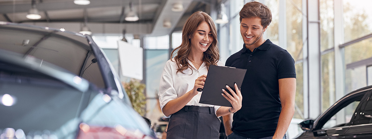 customer speaking with salesperson at a car dealership