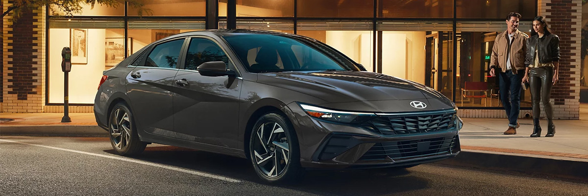 A couple walking up to their parked Hyundai Elantra