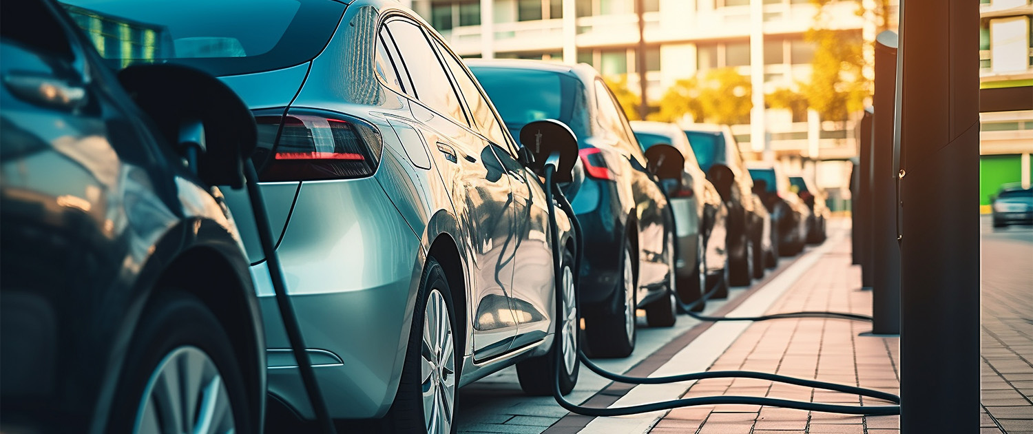 Electric cars lined up on the street charging.