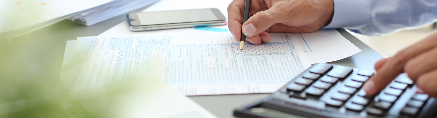 close up of mans hands calculating taxes