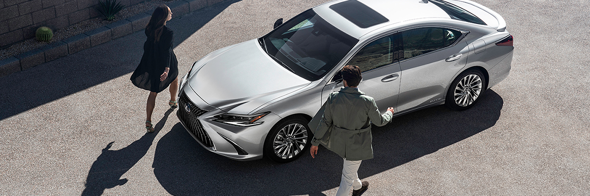 Two people walking up to their Lexus